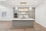 The kitchen is sleek and functional with a LARGE ISLAND for bar seating, upgraded fixtures, and a design that flows effortlessly into the main living