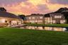 Back of property at dusk with a patio area and a yard