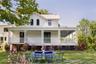 Farmhouse inspired home featuring a front yard, outdoor dining space, and a porch