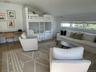 Living area featuring a healthy amount of sunlight, lofted ceiling, wooden walls, and wood finished floors