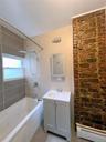 Full bathroom with baseboard heating, vanity, a combined bath / shower with jetted tub, and tile patterned flooring