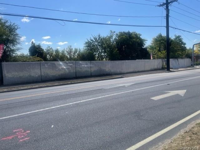 View of asphalt street featuring sidewalks and curbs