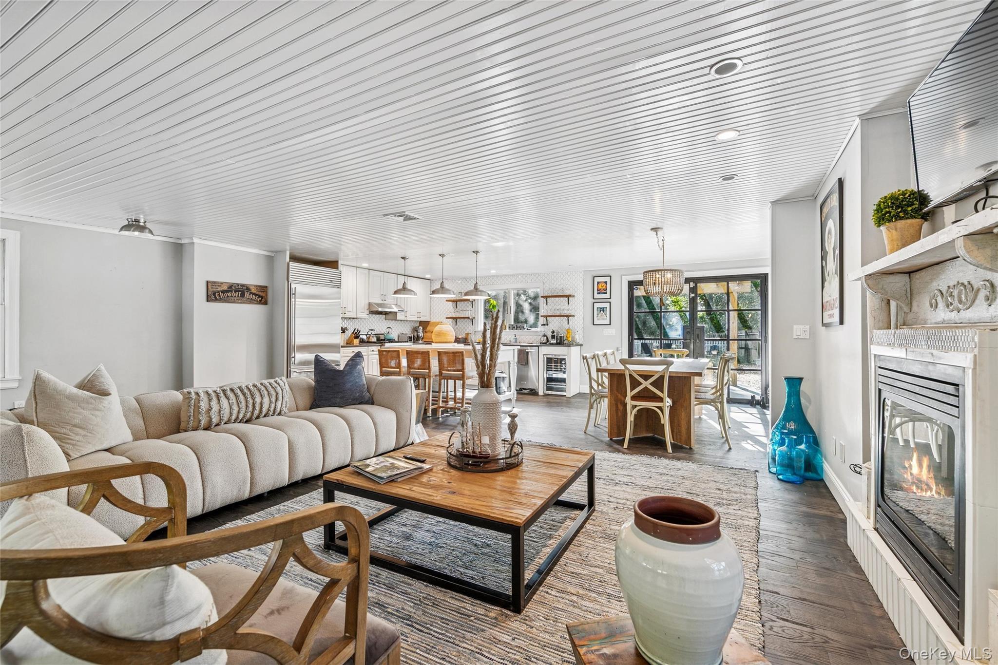 Living area with a glass covered fireplace and wood finished floors