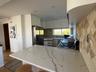 Kitchen with white cabinets, appliances with stainless steel finishes, a peninsula, light wood-style floors, and light stone countertops