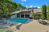 The striking architecture creates a dramatic backdrop for the resort-style pool and outdoor entertaining spaces.