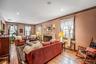 Living area with hardwood / wood-style flooring, radiator heating unit, a fireplace, ornamental molding, and recessed lighting
