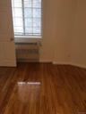 Unfurnished room with wood finished floors and radiator heating unit