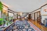 Spacious interior featuring hardwood flooring, detailed crown molding, a built-in fireplace, and double French doors with transom windows
