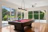 Game Room with view of the Pool and Lake. Beautiful natural wood floor. Sliding Energy effcient doors for the open air experience