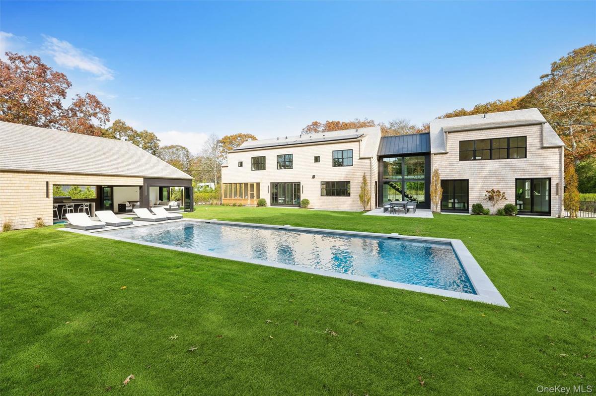 Back of house with a patio, a yard, an outdoor pool, and a metal roof