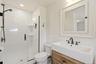 Classically Updated Bathroom with shower and farm-style vanity.