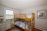Bedroom with a baseboard heating unit, dark wood-type flooring, and recessed lighting