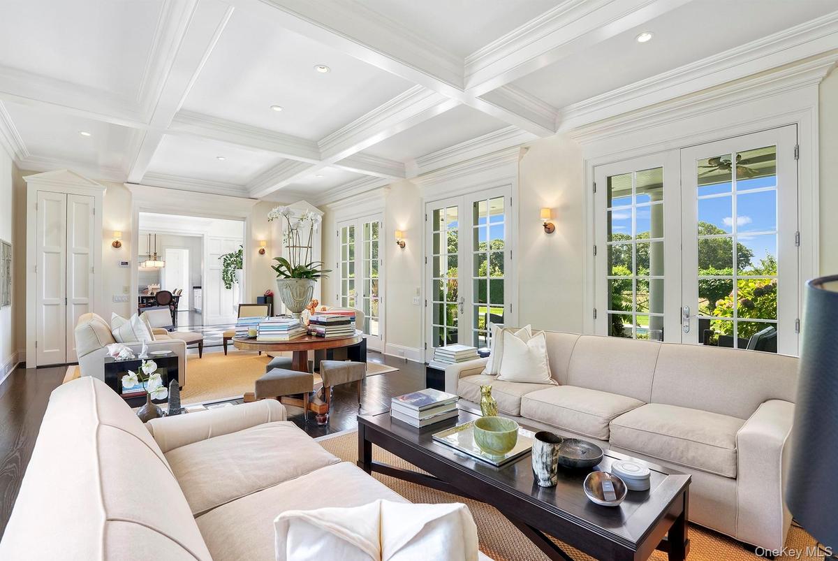 Living area featuring beamed ceiling, wood finished floors, coffered ceiling, french doors, and recessed lighting