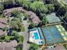 Aerial view showcasing the community pool, multiple tennis courts, and surrounding residential buildings