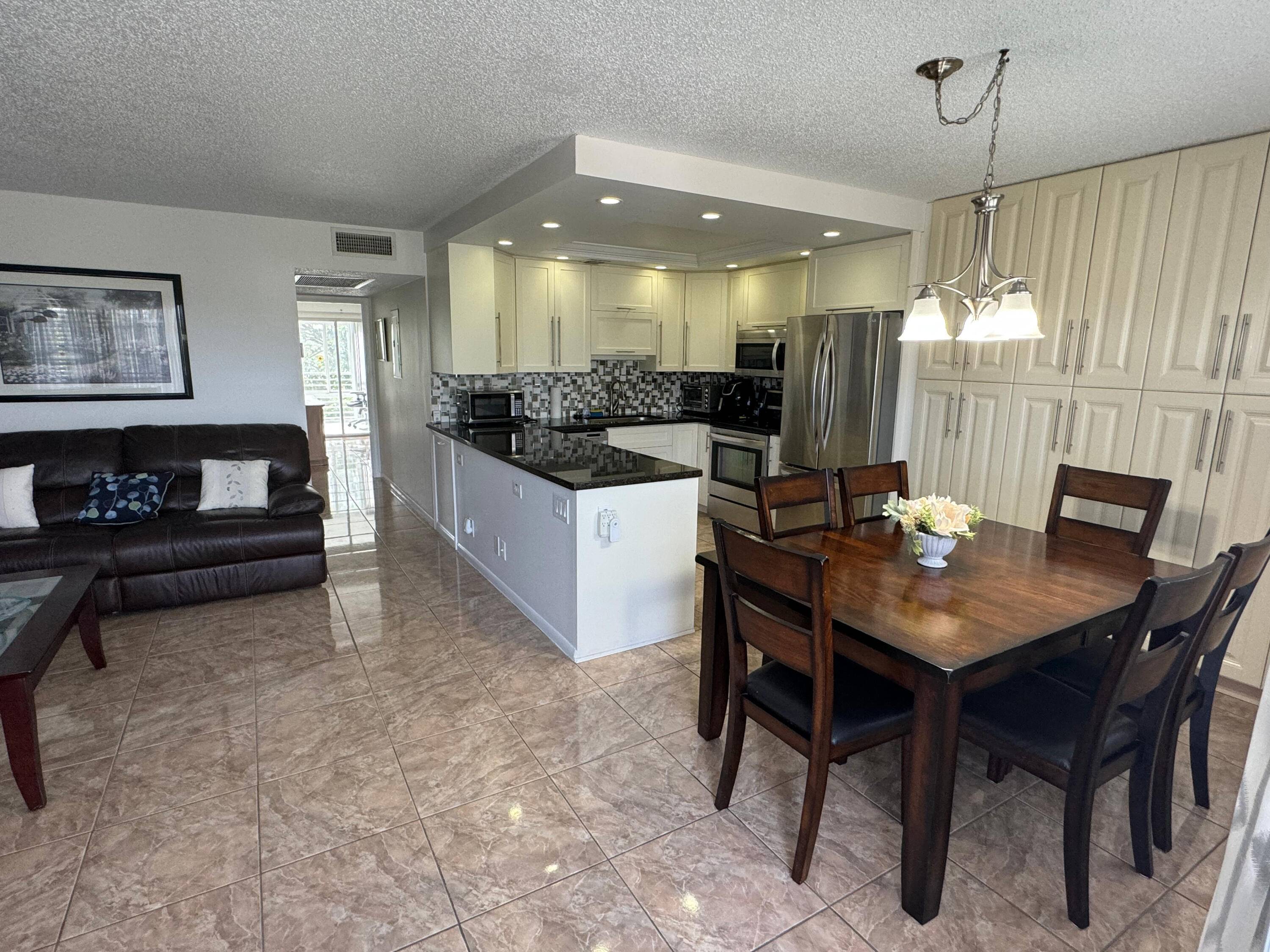 Near the clubhouse and amenities, this updated unit has eliminated the wall between kitchen and living room to create a spacious, open floorplan.