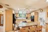 Kitchen featuring decorative backsplash, light stone counters, and breakfast bar area,
