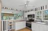 Country kitchen with white cabinetry, stainless steel appliances, and light gray countertops