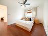 Bedroom with wood finished floors, a ceiling fan, and a baseboard heating unit