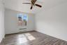 Unfurnished room featuring dark wood-type flooring, radiator heating unit, and a ceiling fan
