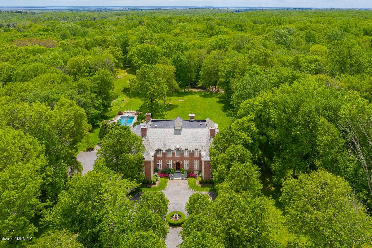 A tree lined driveway leads to this grand 6 BR, 9.