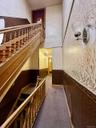 Stairway with carpet flooring and wainscoting