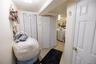 Bedroom with multiple closets, light tile patterned floors, and washing machine and clothes dryer