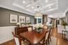 Dining area featuring coffered ceilings with recessed lighting, wood-finish flooring, and wainscoting