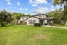 Beautiful corner-lot setting featuring a spacious lawn, mature landscaping, and plenty of outdoor space to enjoy.