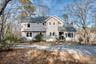 View of front of house featuring a shingled roof and a chimney