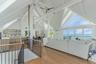 Living area with ceiling fan, a water view, beamed ceiling, plenty of natural light, and high vaulted ceiling