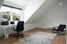 Home office featuring light wood finished floors, a baseboard heating unit, and lofted ceiling