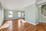 Unfurnished living room with ornamental molding, light wood-style flooring, and stairs