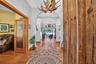 Solid Wood Front Door Opens to a Grand Foyer with Views Through the Living Room to the Swimming Pool