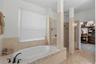 Spa-style primary bath with soaking tub and separate shower.