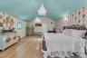 Bedroom with light wood-style floors, wallpapered walls, vaulted ceiling, a chandelier, and an accent wall, 2 walk in closets