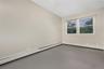 Empty room featuring a baseboard heating unit and finished concrete floors