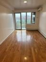 Unfurnished room with light wood-style floors, plenty of natural light, a baseboard heating unit, and a wall mounted AC