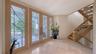 Leaded-glass front door, travertine floors, and staircase to the garage and secondary primary suite