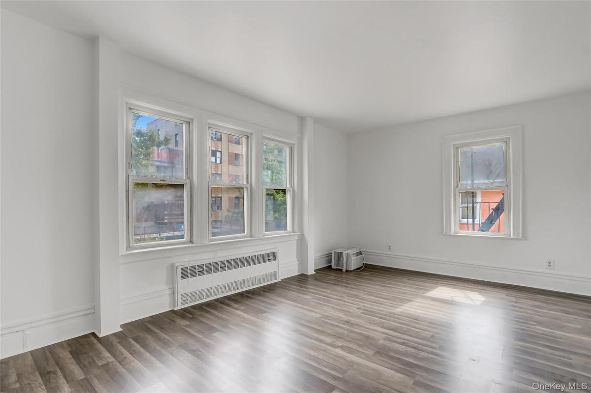 Spare room with radiator heating unit and wood finished floors