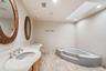Bathroom featuring a built-in corner soaking tub, a skylight, and recessed lighting