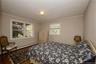 Bedroom featuring dark wood-style flooring, crown molding, and a baseboard heating unit