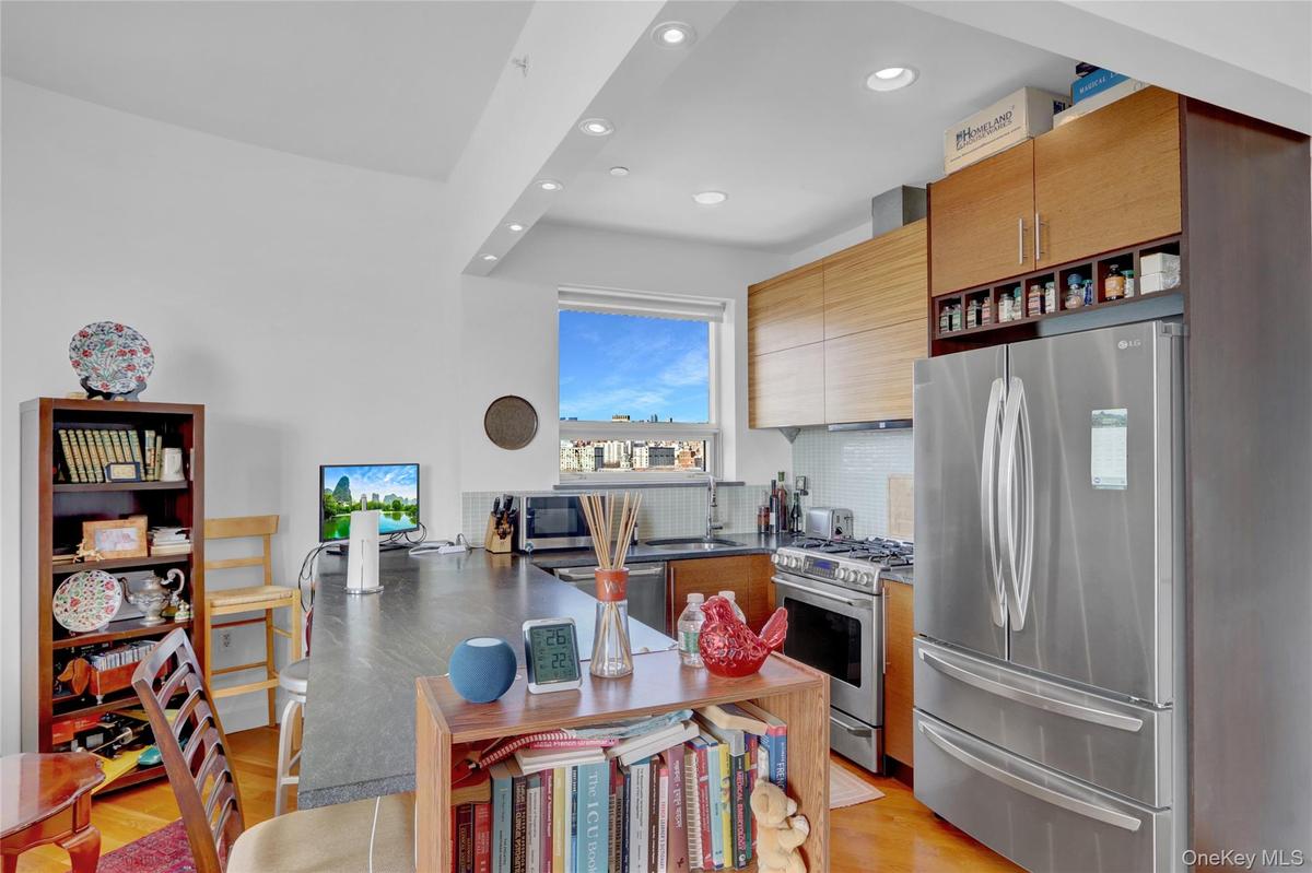 Kitchen featuring stainless steel appliances, light wood finished floors, recessed lighting, decorative backsplash, and open shelves