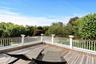 Wooden terrace featuring view of wooded area