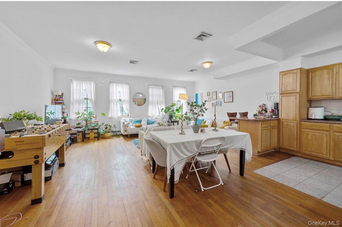 Dining area with light wood-type flooring and crown molding