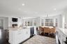 Kitchen with dark wood-style flooring, a lit fireplace, a ceiling fan, dishwasher, and a sink