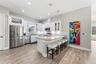 Open-concept kitchen with solid-wood cabinetry, granite countertops, stainless steel appliances, and custom lighting including under-counter kitchen l