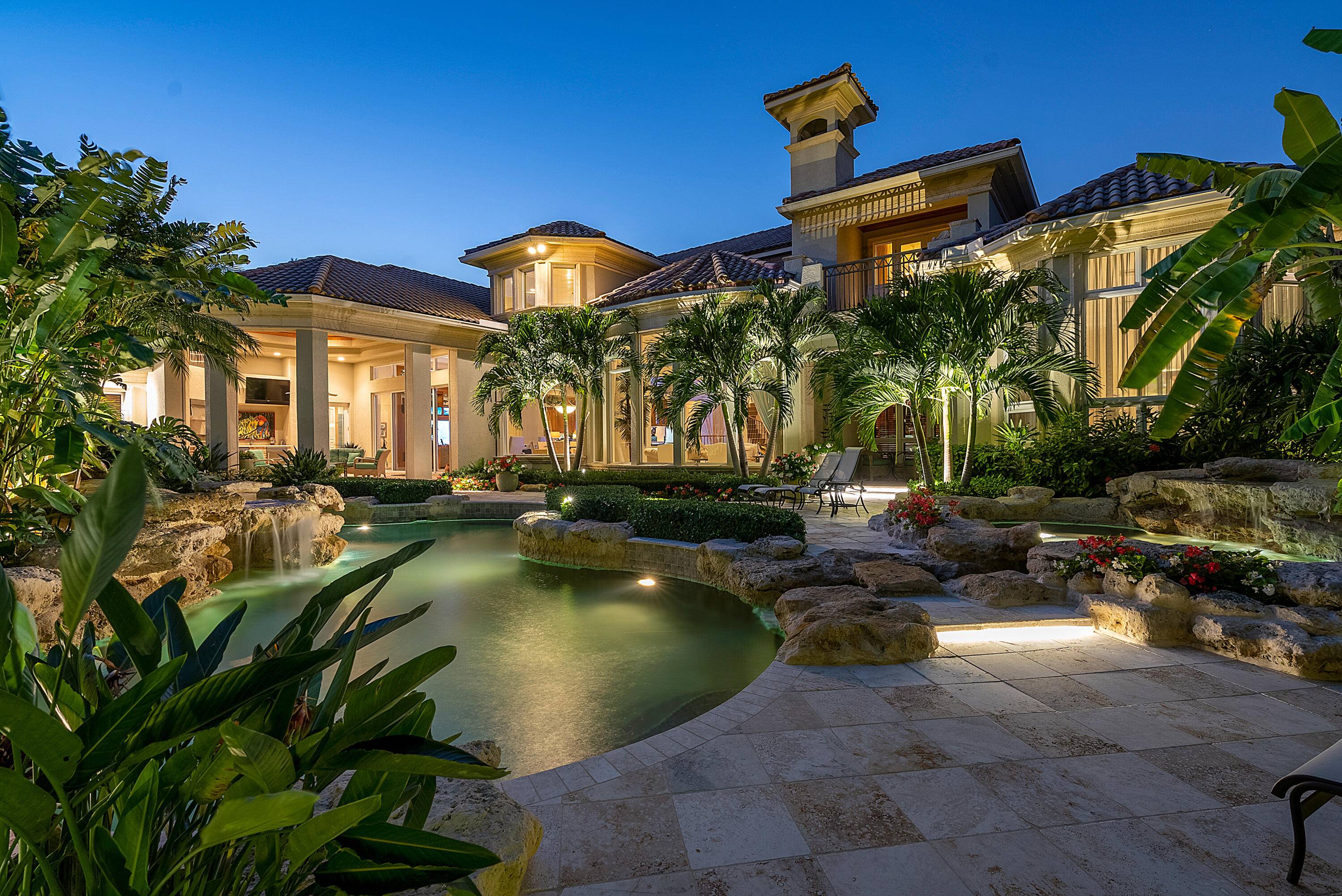 Immerse yourself in the unparalleled beauty of this exceptional waterfront estate, meticulously crafted in the prestigious Royal Palm Yacht Country Club.