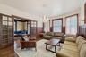 Living room featuring a wainscoted wall, a chandelier, wood finished floors, and french doors