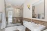 Bathroom with enclosed tub / shower combo, tile walls, and a wainscoted wall