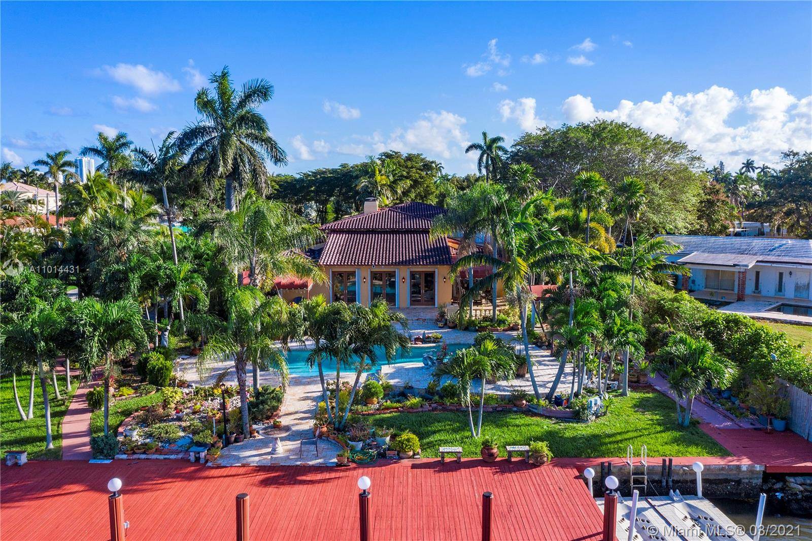 Dramatic Waterfront 4 4 5, 000 sf Mediterranean villa with wide water views and dock on large lot with resort style swimming pool, spa and tennis court surrounded by tropical ...